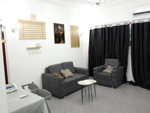 a living room with two chairs and a couch at Moungali avenue terre jaune in Brazzaville +2 photos