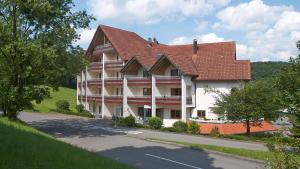 um grande edifício branco com um telhado vermelho em Hotel Jägerhaus em Meckenbeuren