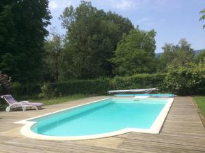 ein Pool mit einem Tisch und einem Stuhl daneben in der Unterkunft Domaine du Valromey in Champagne-en-Valromey