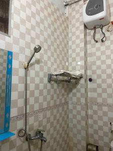 a tiled bathroom with a shower with a toilet at Nhà Nghỉ Long Lưu in Vinh +23 photos