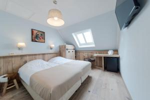 a bedroom with a bed and a table and a television at Hotel Giethoorn in Giethoorn