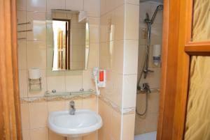 a bathroom with a sink and a shower with a mirror at Bazar Motel in Chişinău