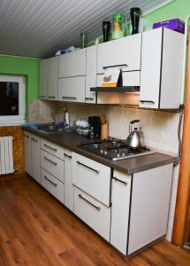 a kitchen with white cabinets and a stove top oven at Bazar Motel in Chişinău