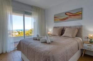a bedroom with a large bed with a large window at New sunset views in Torrox Costa