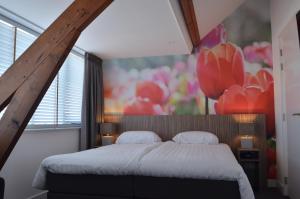 a bedroom with a bed and a painting on the wall at Hotel Restaurant de Engel in Lisse
