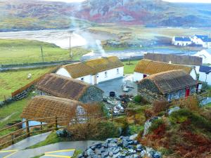 een groep huizen met rieten daken op een heuvel bij Abbey Hotel Donegal in Donegal