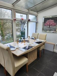 Cherrywood Lodge في لوي: غرفة طعام مع طاولة وكراسي خشبية كبيرة