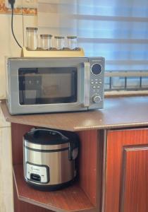 a microwave sitting on top of a kitchen counter at Nadi Homes in Dar es Salaam +10 photos