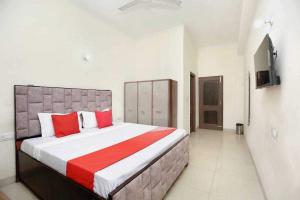 a bedroom with a large bed with red pillows at OYO 91941 Hotel golden crown in Sirhind