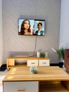 a living room with a tv on a wall at Nadi Homes in Dar es Salaam