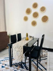a dining room with a black table and chairs at Nadi Homes in Dar es Salaam