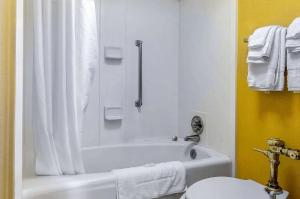 a bathroom with a white tub and a toilet at Quality Inn University Area in Troy