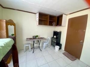 a bedroom with a table and chairs in a room at Matthew's Place in Cagayan de Oro +6 photos