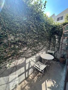 a table and chairs in front of a wall at Stylish apartment in Chapultepec in Guadalajara