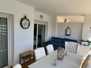 a living room with a table and a clock on the wall at Mi Capricho, Luxury Apartment in Mijas Costa