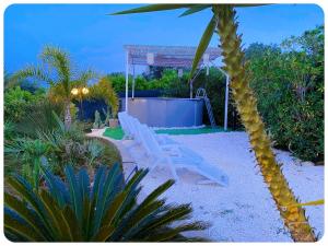 un par de sillones blancos en un jardín en CASALE VISTA ADUA, en Ostuni