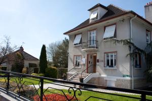 a white house with a balcony and a yard at Belvedere Montargis Amilly in Amilly