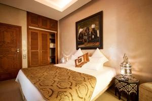 a bedroom with a bed and a painting on the wall at Riad Flam & Spa in Marrakesh