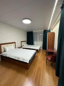 a bedroom with two beds and a table at Comfy apartment in Central UB in Ulaanbaatar +4 photos