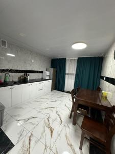 a kitchen with a table and a dining room at Comfy apartment in Central UB in Ulaanbaatar
