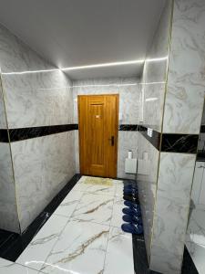 a bathroom with a door and a marble floor at Comfy apartment in Central UB in Ulaanbaatar +4 photos