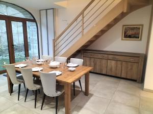 a dining room with a wooden table and chairs at La petite favière in Cult