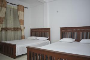 two beds sitting next to each other in a room at The Cave Retreat in Kitulgala