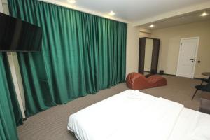 a hotel room with a bed and green curtains at Da Vinci Hotel in Almaty +21 photos