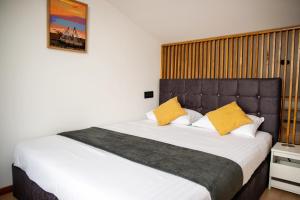 科尔布Loggia Corbu的卧室里有一张大床，上面有黄色枕头