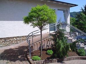 ein Baum vor einem Haus mit einer Treppe in der Unterkunft Ferienwohnung Eigner in Traben-Trarbach