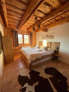 een slaapkamer met een bed in een kamer met houten plafonds bij Apartmány Starý mlyn in Habovka