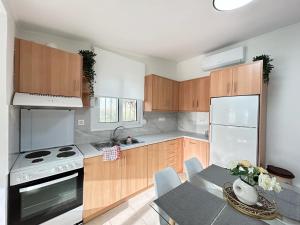 a kitchen with wooden cabinets and a table and a stove at Κτημα Εριφυλλη in Khóra