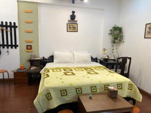 een slaapkamer met een bed met een gele deken erop bij Lotus Homestay 2 in Hanoi