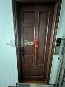 een bruine deur met een bord erop bij Lotus Homestay 2 in Hanoi