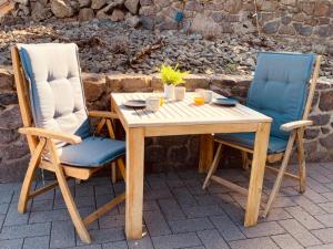 a wooden table and two chairs sitting next to each other at Ferienwohnung Auszeit in Kelberg