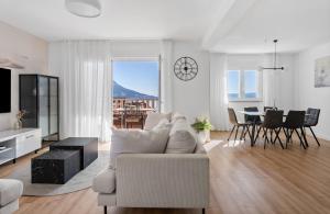 een witte woonkamer met een bank en een tafel bij Apartments Bakota in Omiš