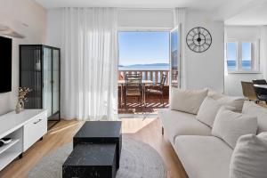 een woonkamer met een witte bank en een tafel bij Apartments Bakota in Omiš