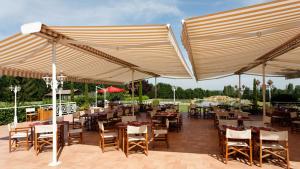 a restaurant with tables and chairs under a canopy at Le Relais Des Chartreux in Saulx-les-Chartreux