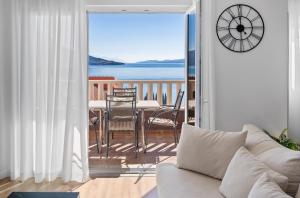 een woonkamer met een bank en een klok op een balkon bij Apartments Bakota in Omiš