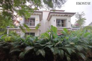 ein weißes Haus mit Bäumen davor in der Unterkunft EKOSTAY - Casa Enzo in Lonavla + 27 Fotos
