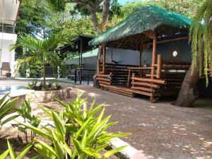 un padiglione con un tetto di paglia su un edificio di The Barkly House Staycation a Biñan