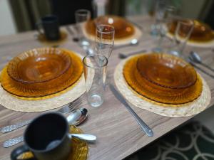 ein Holztisch mit Tellern und Gläsern darauf in der Unterkunft Casa Rolo in Tenosique de Pino Suárez