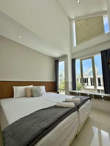 a large white bedroom with a large bed with windows at City side retreat Adelaide house in Tambakmanukan