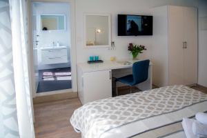 1 dormitorio con cama, escritorio y lavamanos en Luxury rooms Skystar-Split, en Split