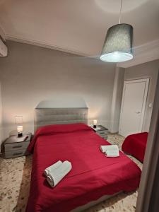 sypialnia z czerwonym łóżkiem i 2 ręcznikami w obiekcie Etnea Gioeni House Suite w Katanii +37 zdjęć
