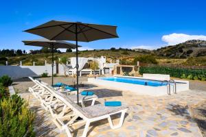 a pool with umbrellas and chairs and a swimming pool at Calm and Joy Summer House in Afantou