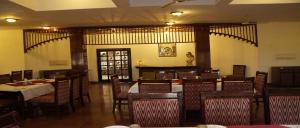 a dining room with tables and chairs in a restaurant at Blue Bird in Hisār