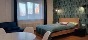 une petite chambre avec un lit et une table dans l'établissement Center & homely Apartment, à Klaipėda
