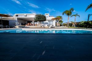 a swimming pool in front of a house at Aria Oasi Relax in Agrigento