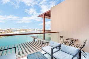 einen Balkon mit Stühlen und Blick auf das Wasser in der Unterkunft Beautiful Palm Studio with a Wow View in Dubai